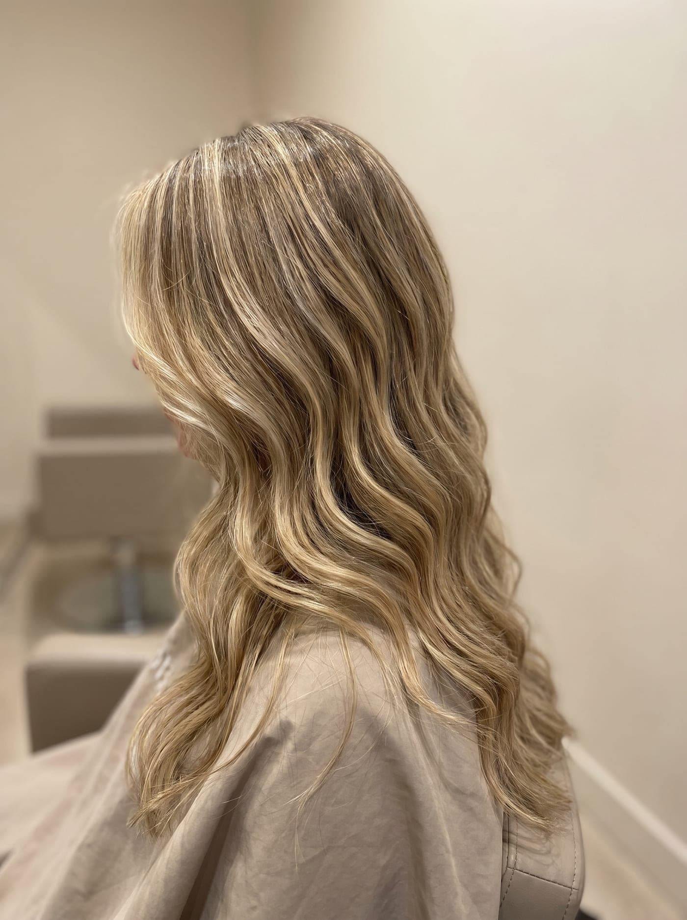 Sun-kissed blonde balayage on long glossy waves