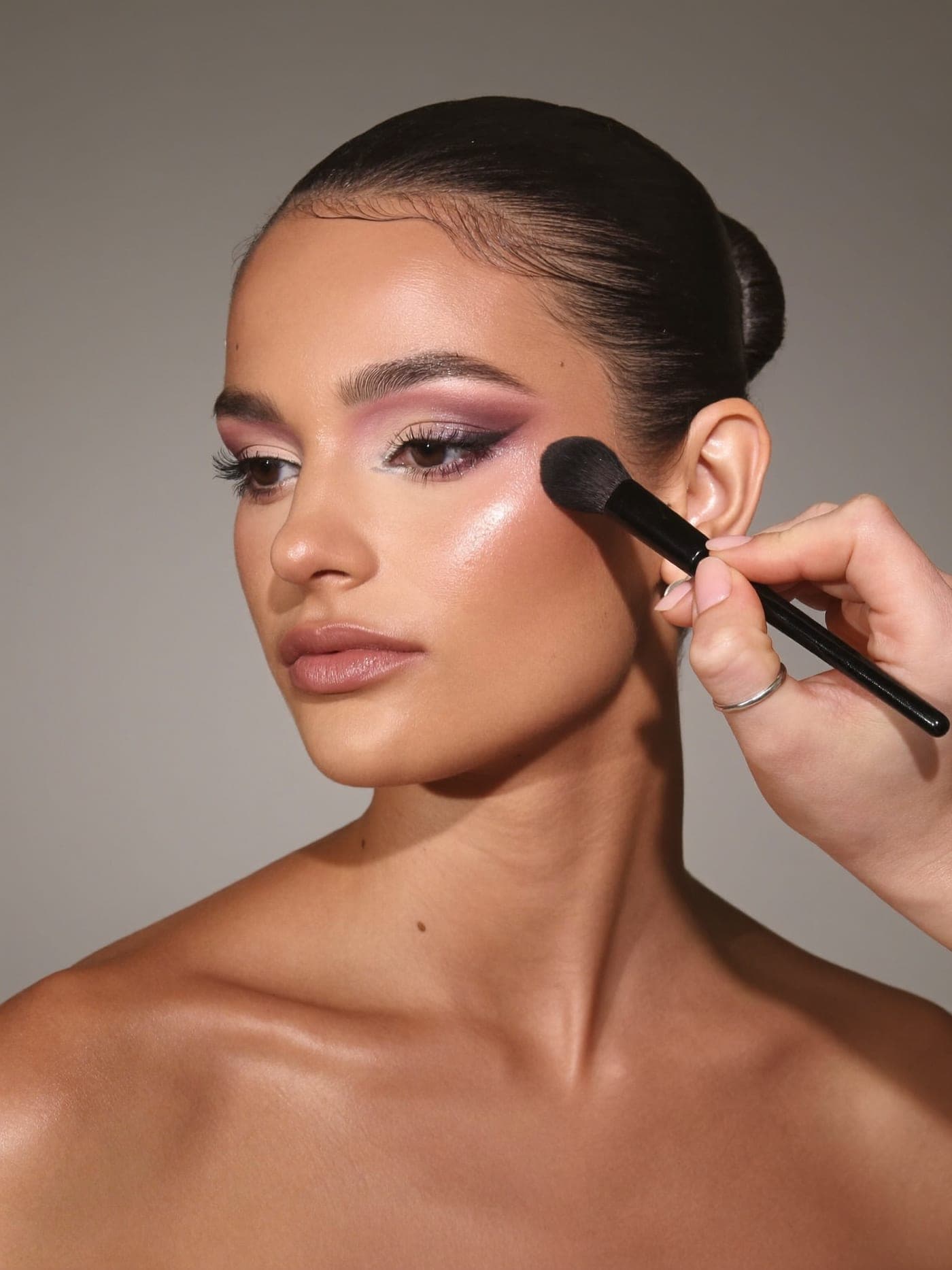 A makeup artist finishing a polished look
