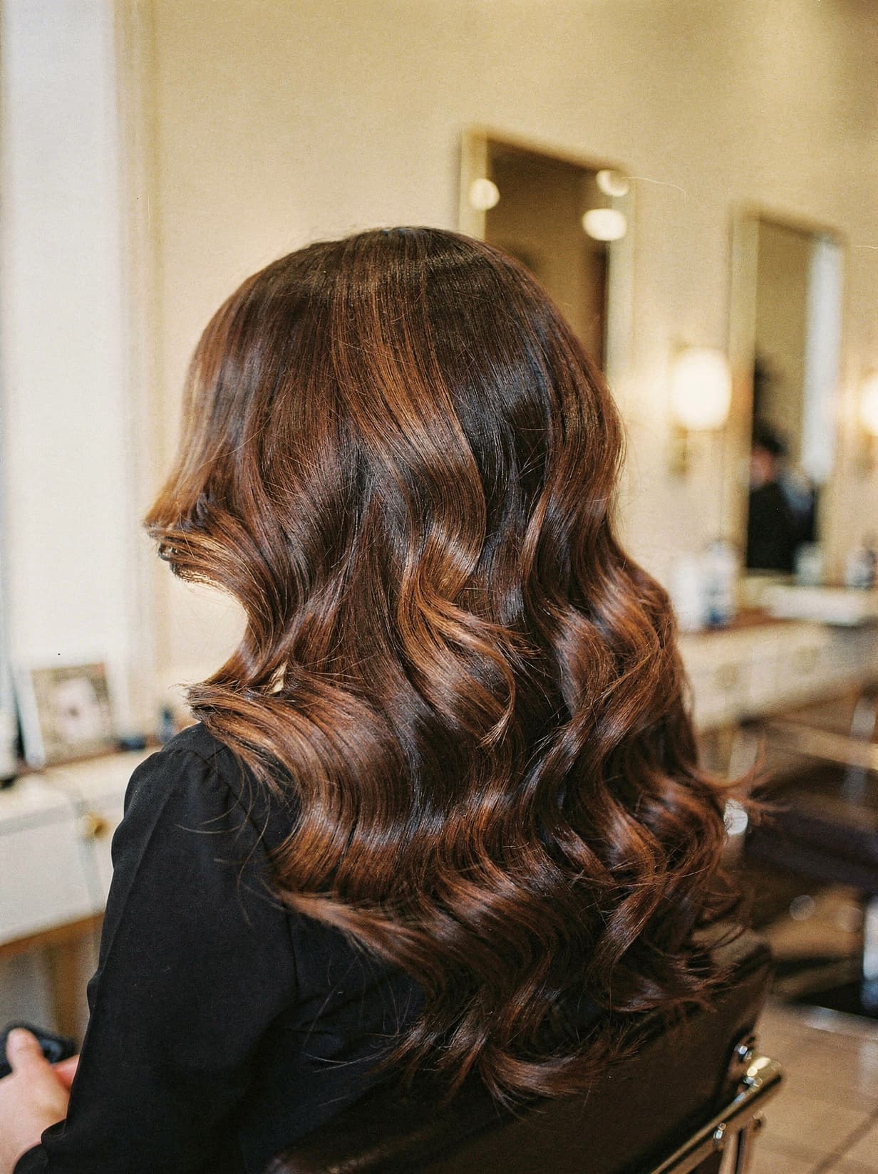 Deep caramel-brunette Hollywood waves with sculpted shine